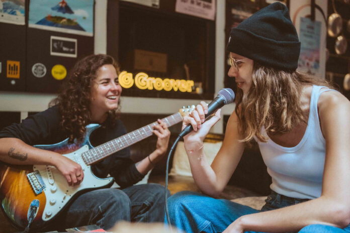 Two musicians performing together in the Groover studio