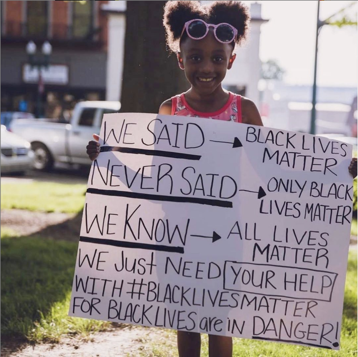 Girl holding sign explaining what black lives matter means
